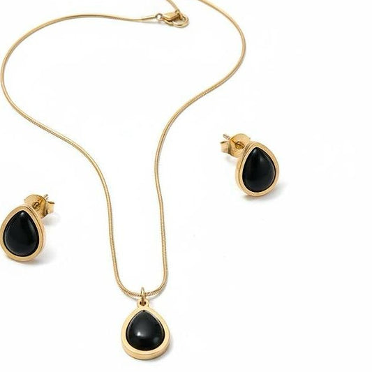 Jewelry set with black teardrop pendants on a gold chain and earrings.