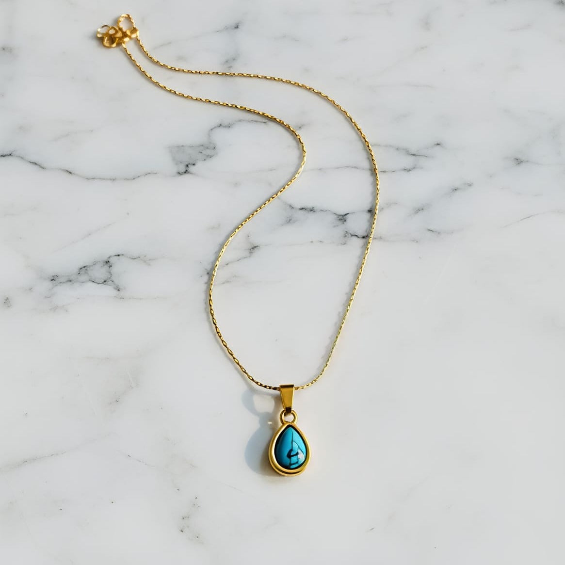 Gold necklace with a turquoise pendant  