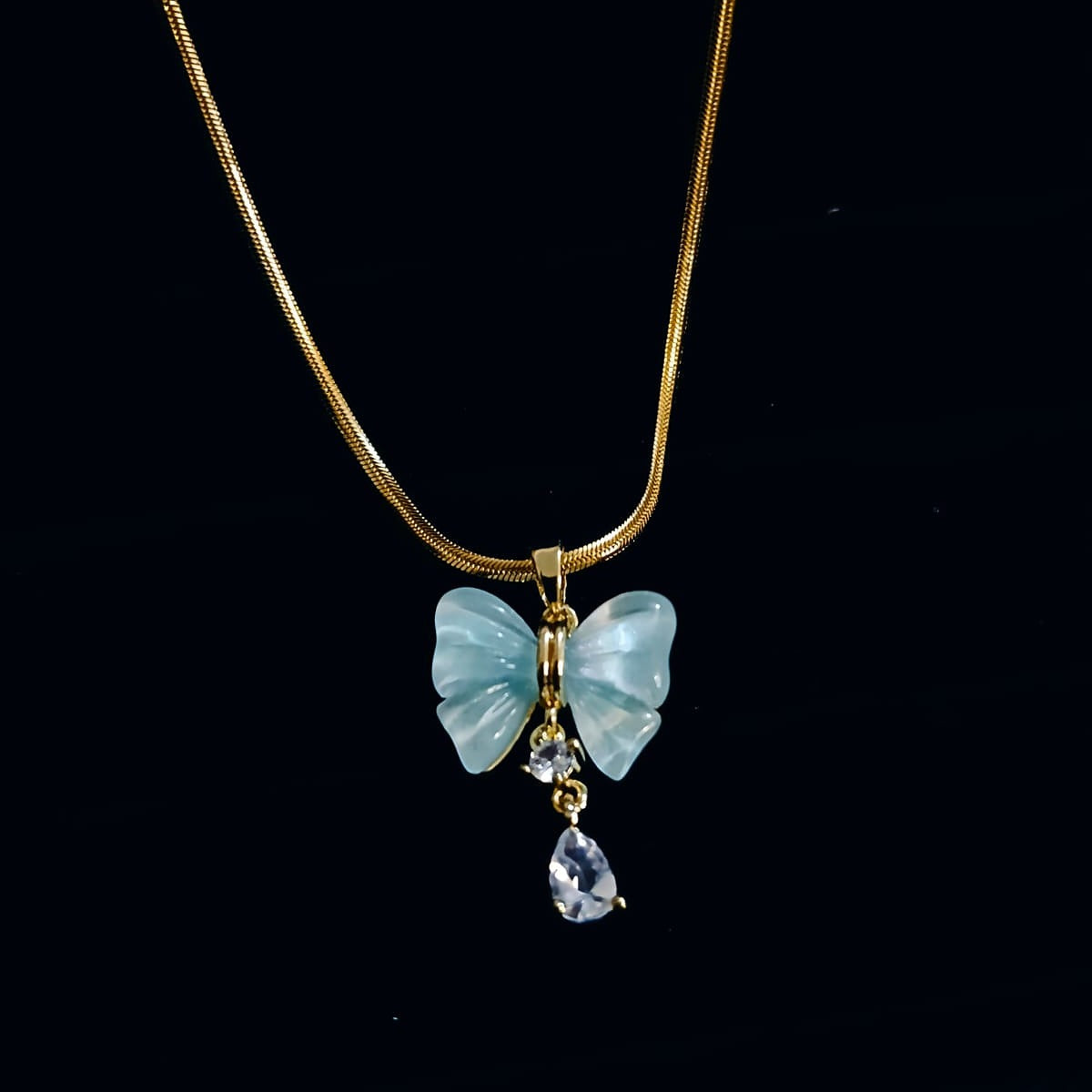 Butterfly-shaped pendant with gemstones on a gold chain  