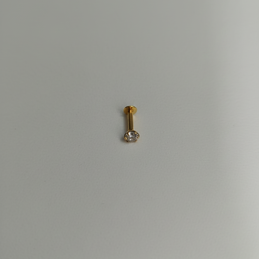 Gold earring with a clear gemstone
