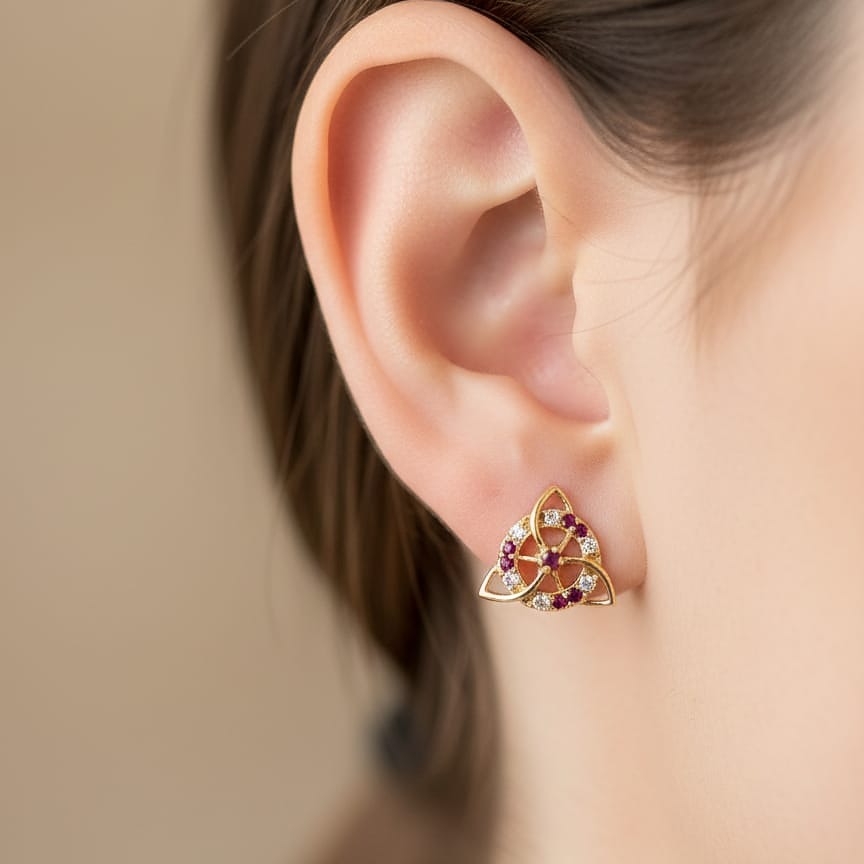 Gold triangular earring with gemstones worn 