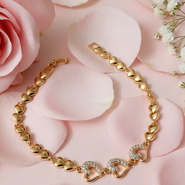 Gold bracelet with heart designs on a pink floral background