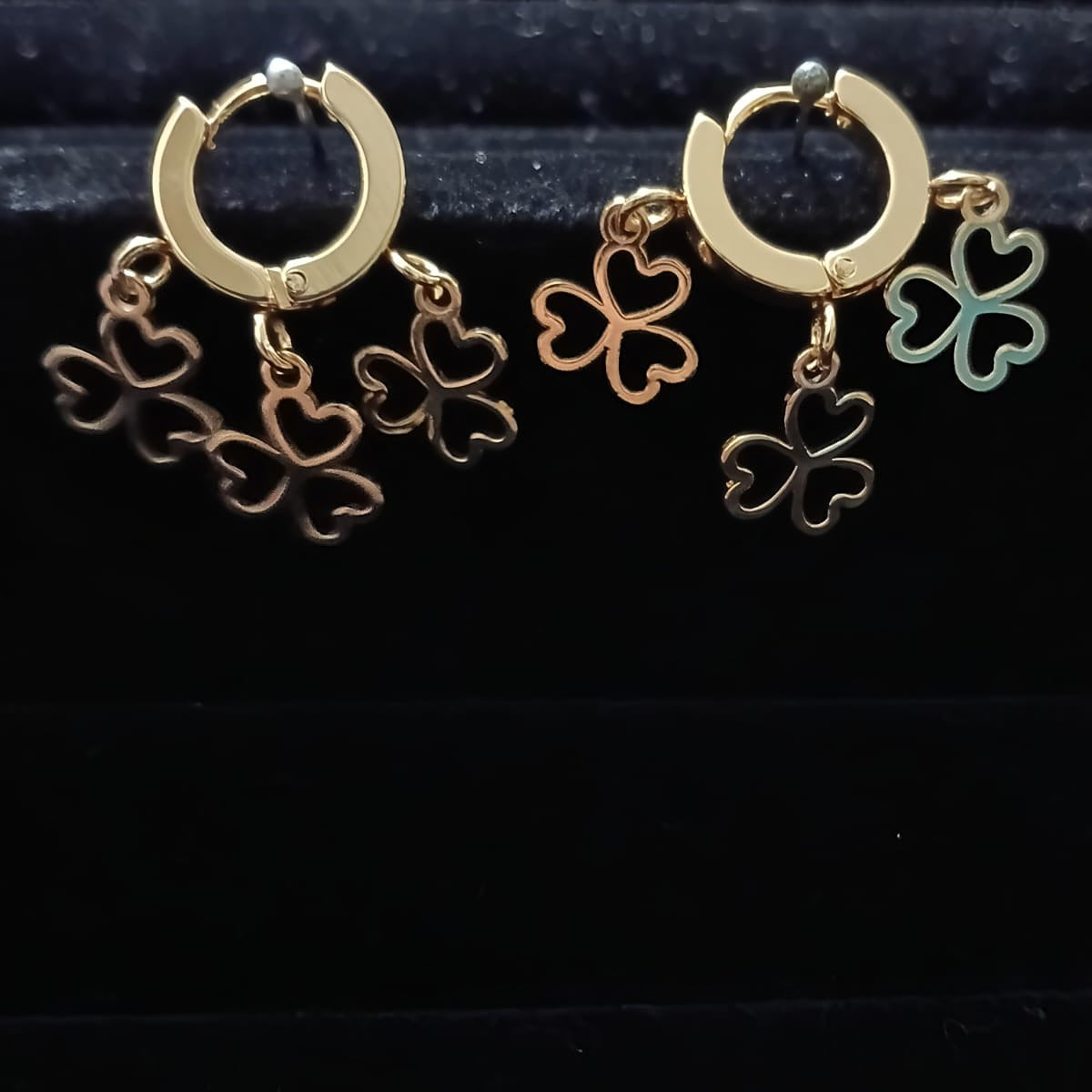 Gold hoop earrings with clover-shaped charms 