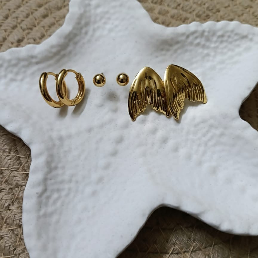 Gold hoop earrings and wing-shaped earrings