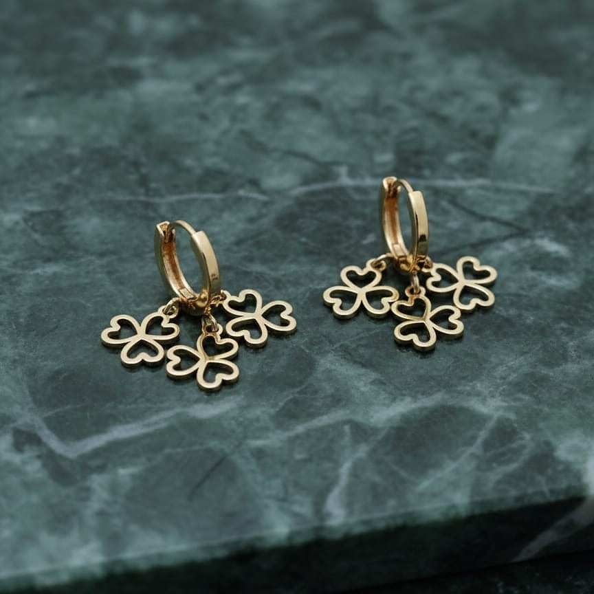 Gold hoop earrings with clover-shaped charms