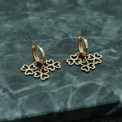 Gold hoop earrings with clover-shaped charms