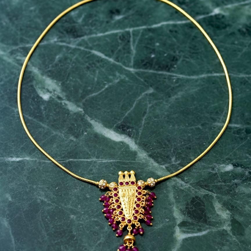 Gold necklace with a purple pendant 