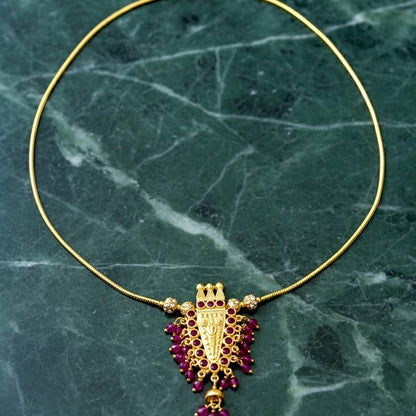 Gold necklace with a purple pendant 