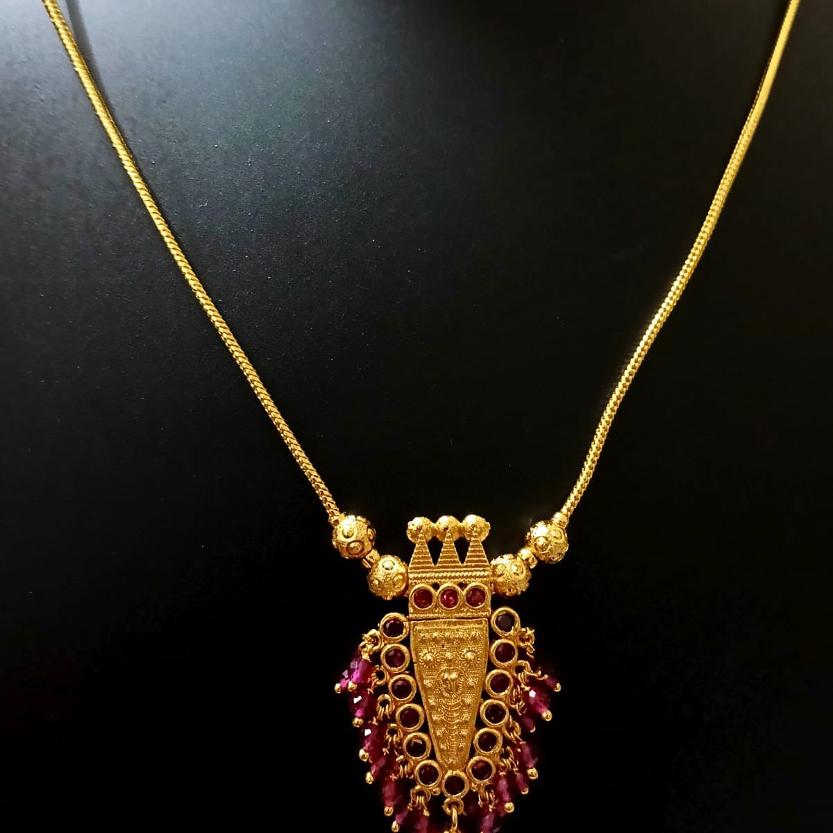 Gold necklace with a purple pendant 