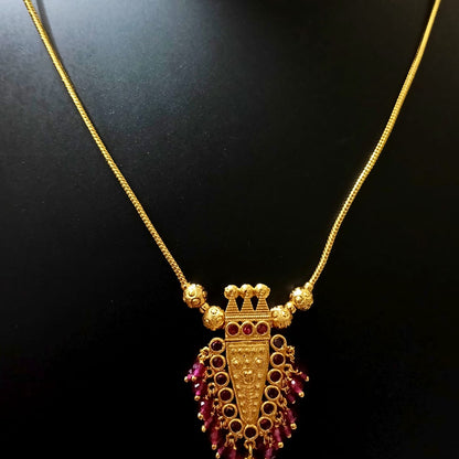 Gold necklace with a purple pendant 