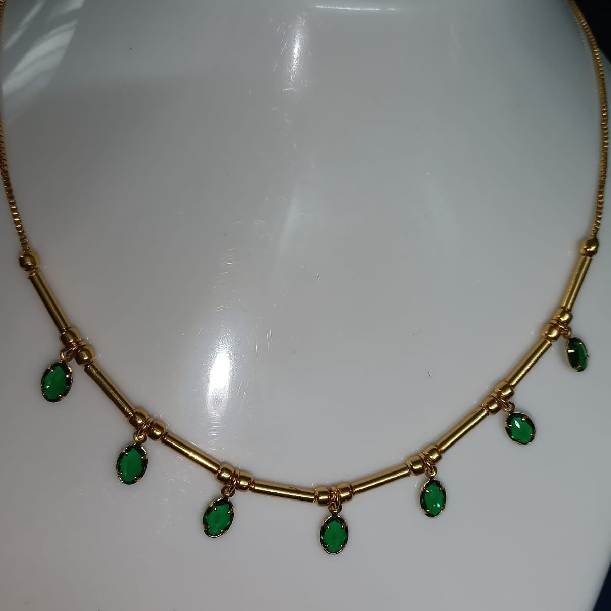 Gold necklace with green gemstones 