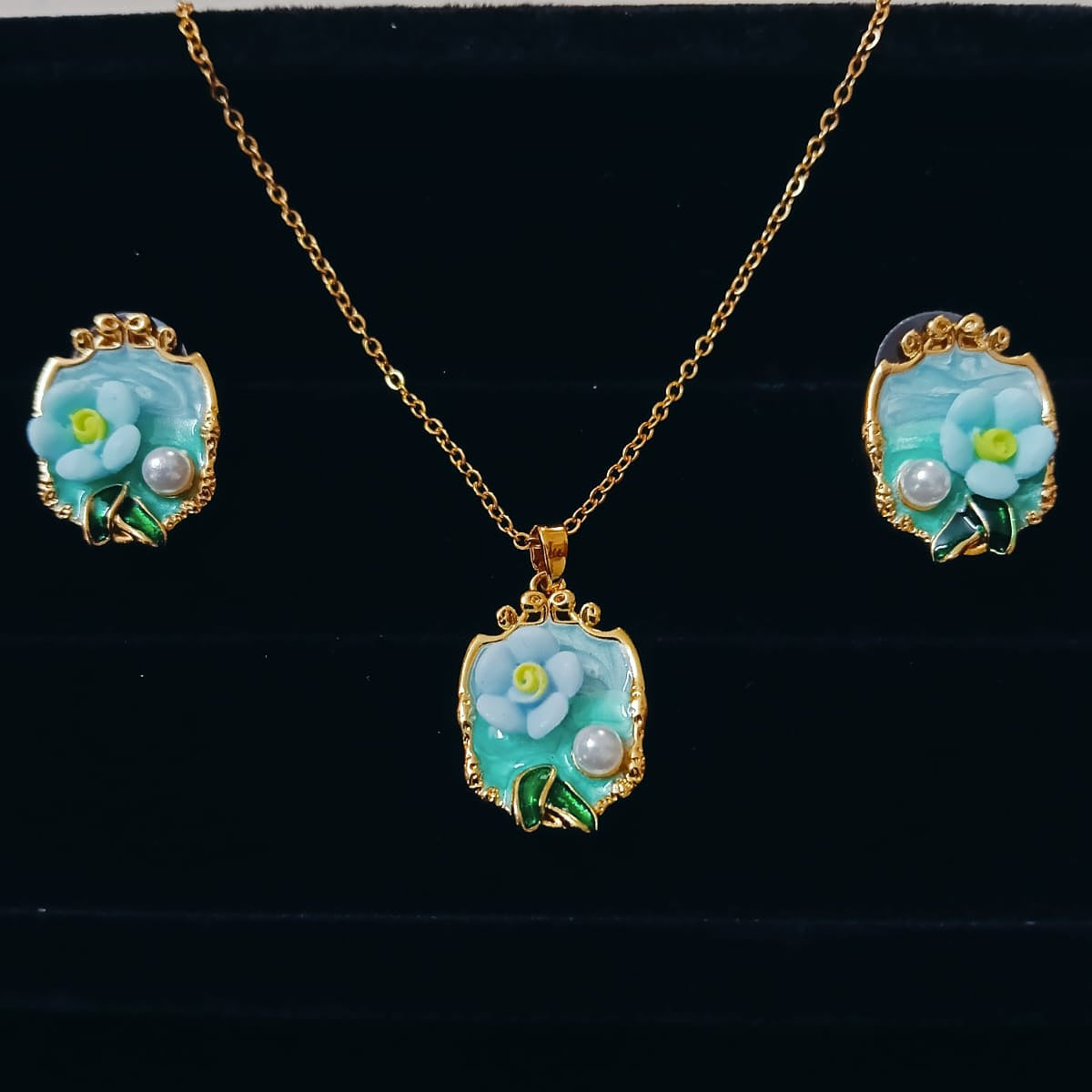 Jewelry set with pendant and earrings featuring floral designs