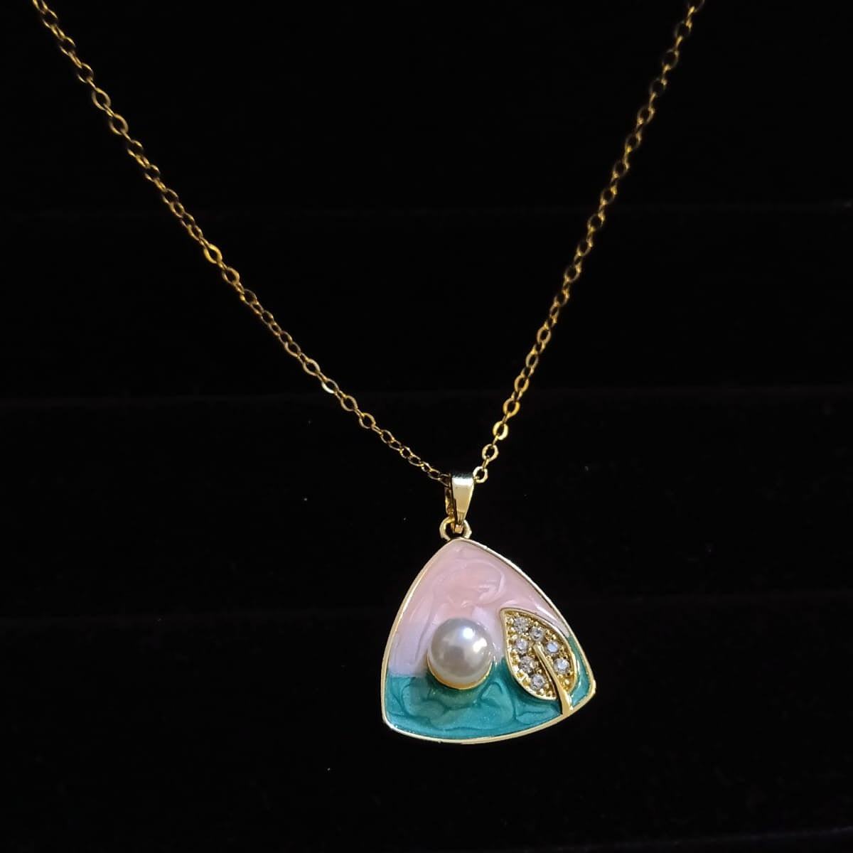 Necklace with a pendant featuring a pearl and leaf design  