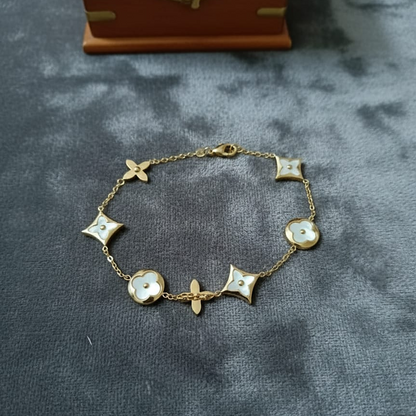 Gold bracelet with decorative elements on a gray surface