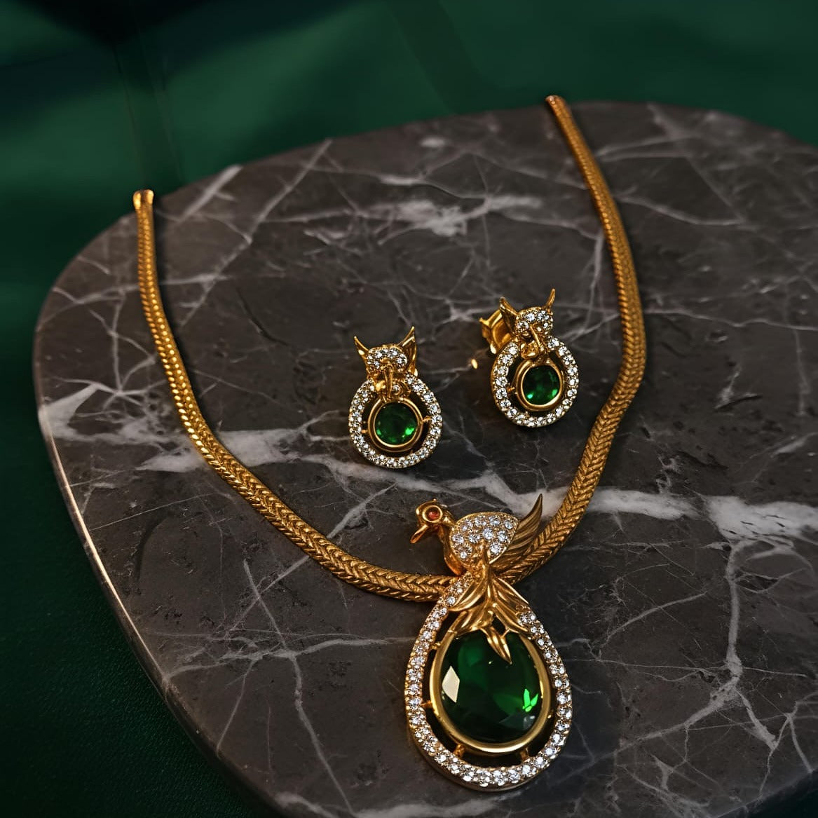 Gold necklace and earrings with green gemstones