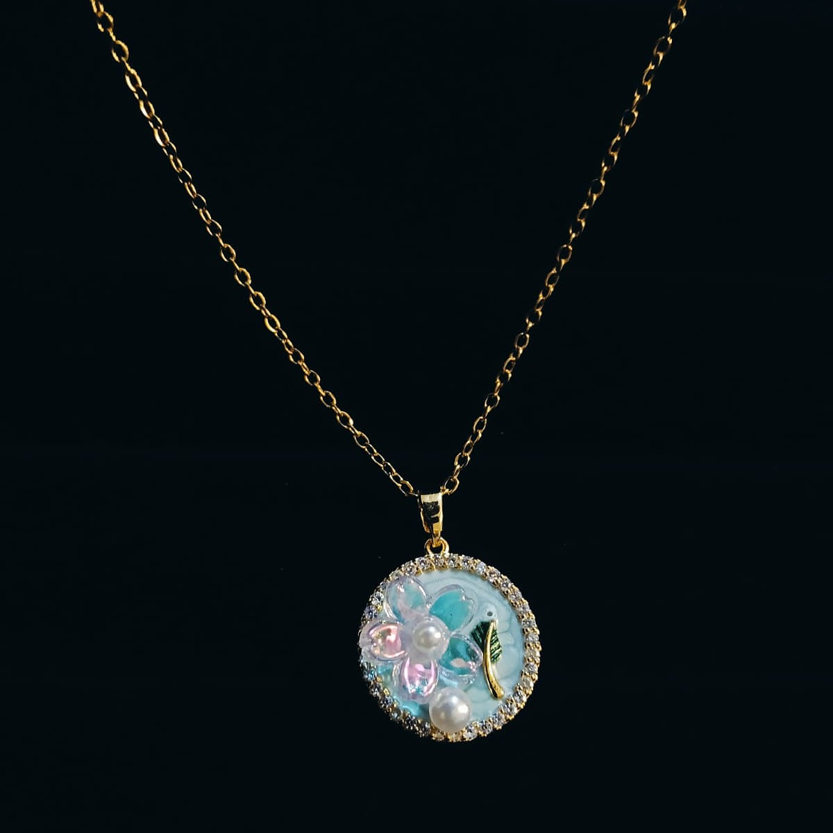 Necklace with a round pendant featuring floral designs  