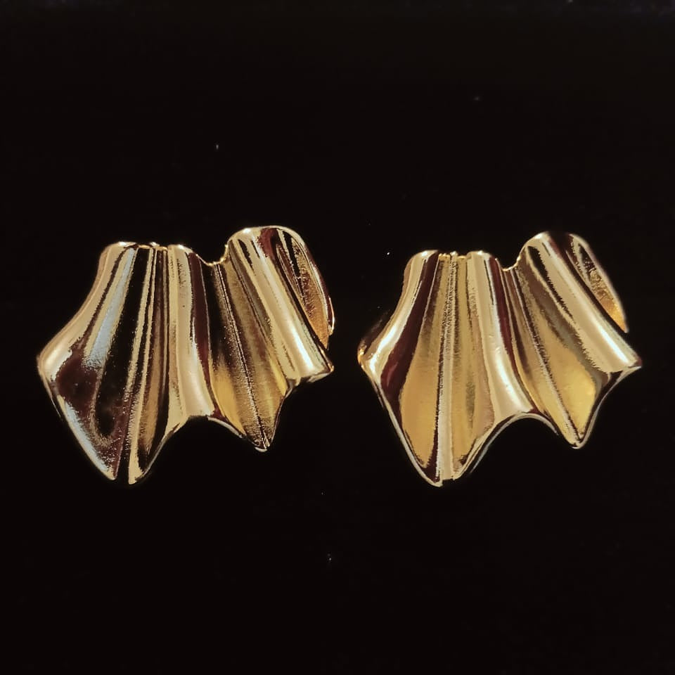 Pair of gold earrings on a black background
