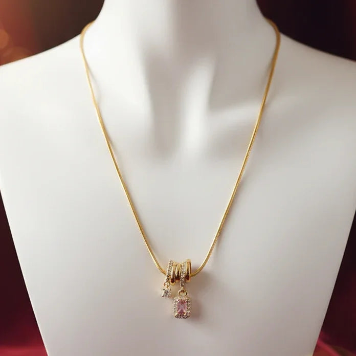 Gold necklace with a pink pendant on a mannequin