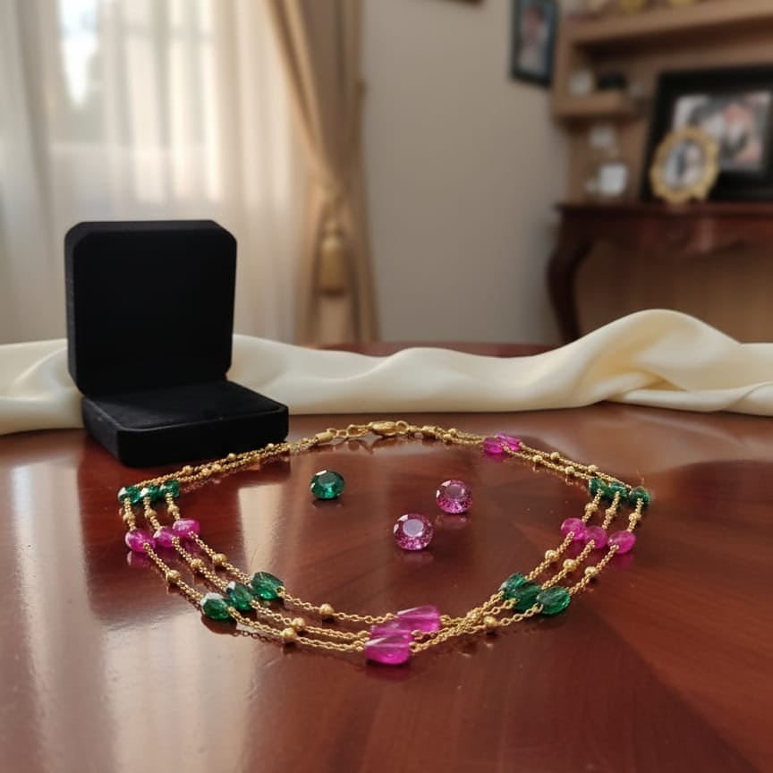 Gold necklace with green and pink gemstones