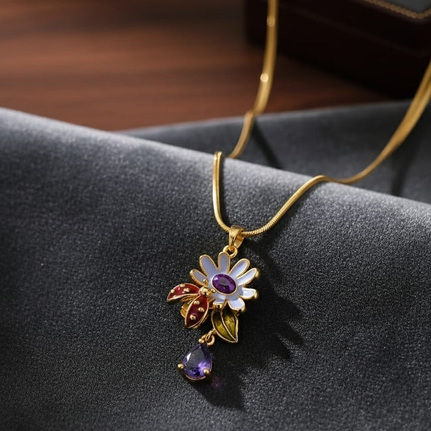 Gold necklace with a floral pendant on a dark fabric background