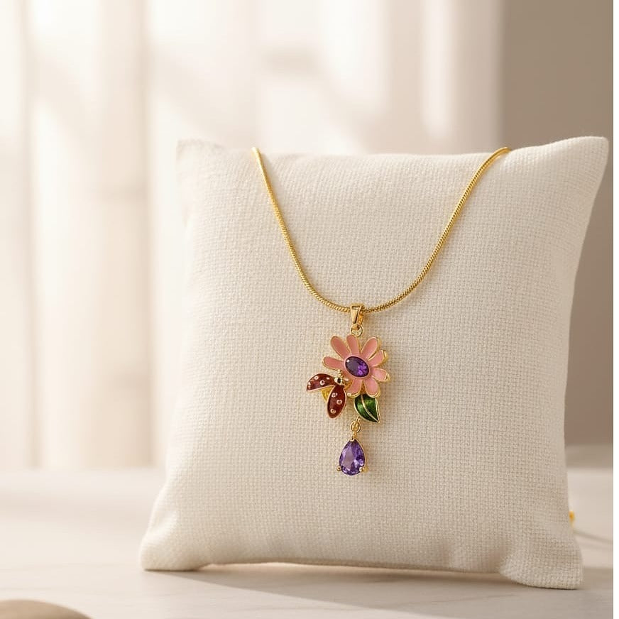 Necklace with a floral pendant and purple gemstone on a white cushion