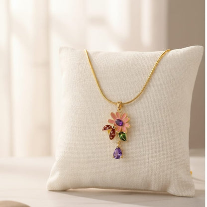 Necklace with a floral pendant and purple gemstone on a white cushion